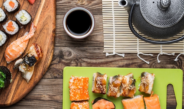 Rolos de sushi japonês com molho de soja e bule