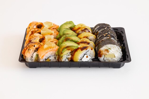 Rolos de sushi japonês com salmão, abacate e camarão em branco