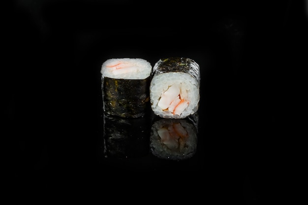 Rolos de sushi japonês fresco tradicional em um fundo preto