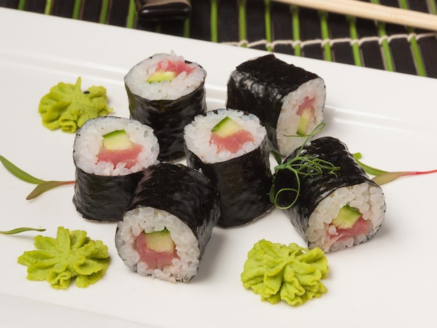 Rolos de sushi Maki com atum e pepino em uma placa branca closeup