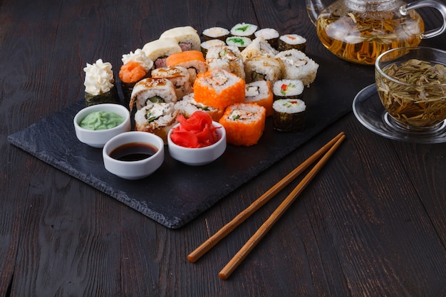 Rolos de sushi maki e nigiri frescos e deliciosos e copo de chá verde