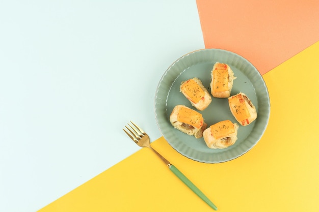 Rolos mini de croissant de queijo flat lay na placa de cerâmica, conceito snacking com espaço de cópia para texto