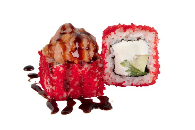 Rolos de sushi deshuesados en caviar artificial rojo y vertidos con salsa de soja en un primer plano de fondo blanco
