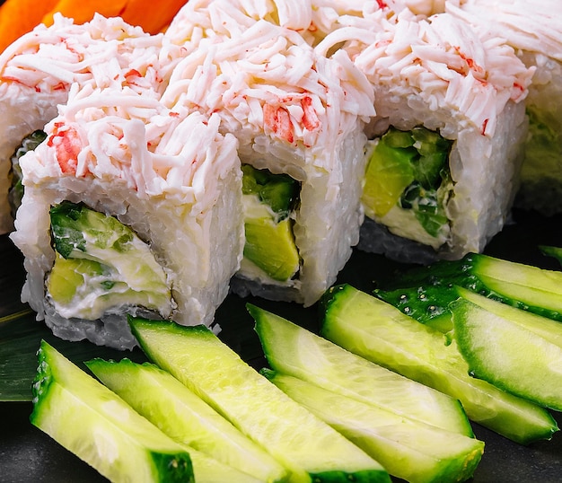 Rolos de sushi con palitos de cangrejo y pepinos