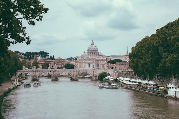 Rom, Italien, 22. Juni 2018: Panoramablick auf die päpstliche Basilika St. Peter (Petersdom) im Vatikan und den Fluss Tiber mit Brücke in Rom. Sommertag