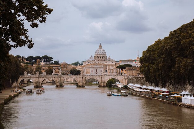 Rom, Italien, 22. Juni 2018: Panoramablick auf die päpstliche Basilika St. Peter (Petersdom) im Vatikan und den Fluss Tiber mit Brücke in Rom. Sommertag