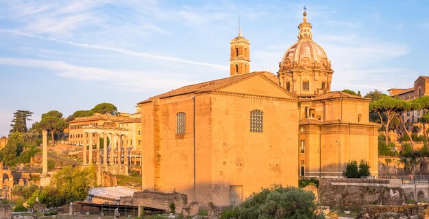 ROM, ITALIEN - CIRCA AUGUST 2020: Sonnenaufgangslicht mit blauem Himmel auf der römischen antiken Architektur.