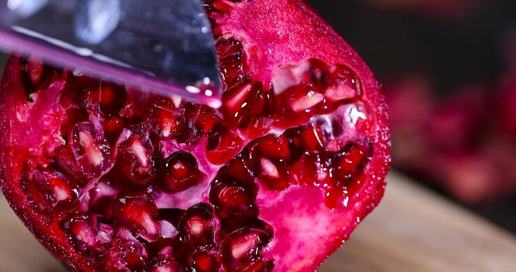romã cortada de perto romã doce cortada em pedaços durante a cozinha