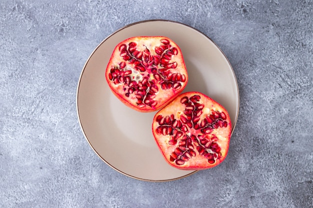 Foto romã fruta cortada ao meio e servido em um prato