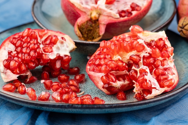 Romã madura suculenta fresca em um fundo de madeira, close-up. Fruta de romã cortada ao meio