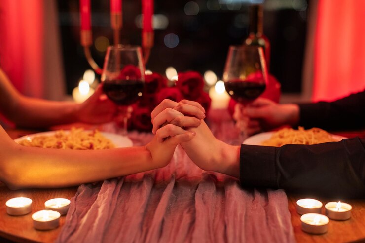 Foto romance e amor em close-up de um casal de mãos dadas sentado à mesa num restaurante a beber vinho e