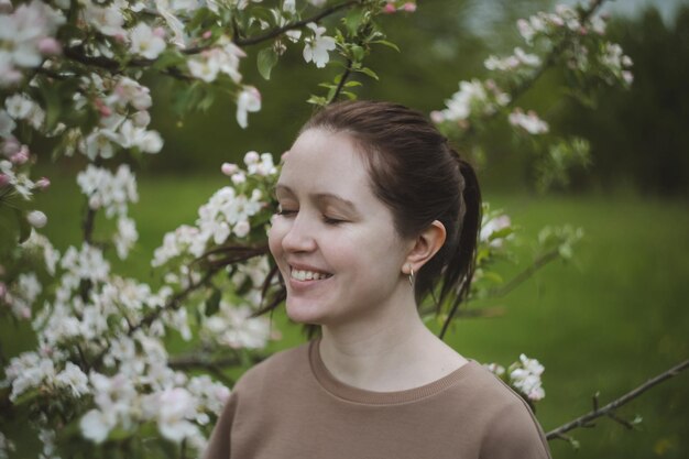 Romántica mujer joven en el jardín de primavera entre flor de manzana