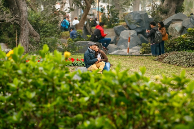 romántica pareja de adultos jóvenes sentados en un banco del parque