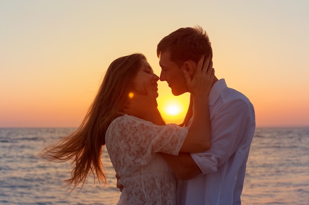 Romántica pareja besándose en la playa