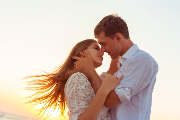 Romántica pareja besándose en la playa