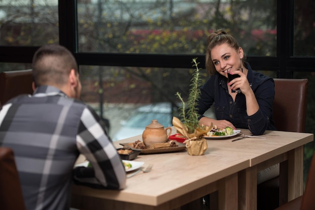 Romántica pareja joven en la mesa del restaurante tostado