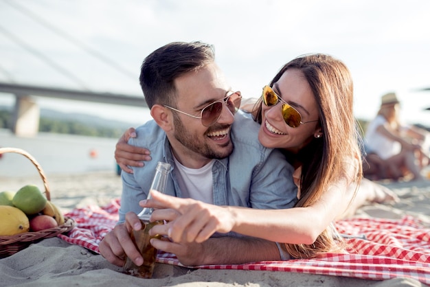 Romántica pareja joven en la playa disfrutando juntos