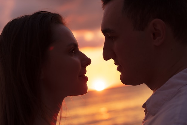 Romántica pareja joven sensual enamorada en la puesta del sol