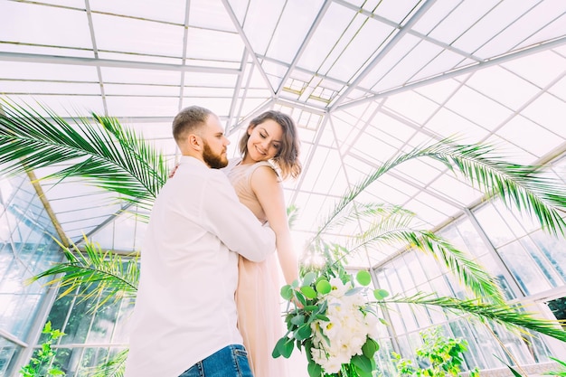 Romántica pareja de recién casados, el novio y la novia se divierten en medio de la vegetación