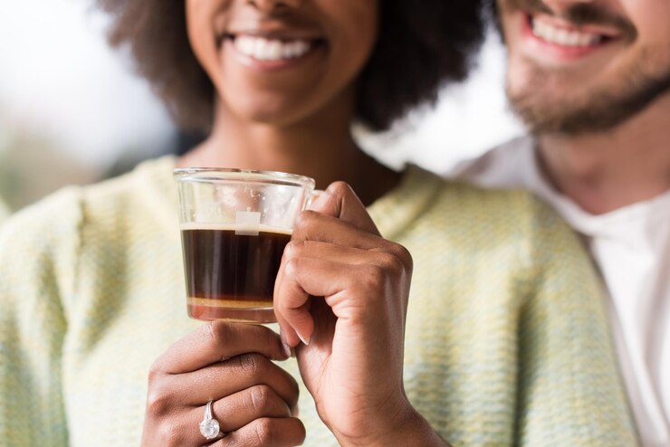 Foto romântico feliz jovem casal multiétnico desfrutando de café da manhã pela janela em sua casa de luxo