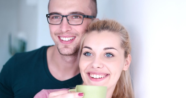 romántico joven pareja feliz disfrutando de café por la mañana en la ventana de su casa de lujo