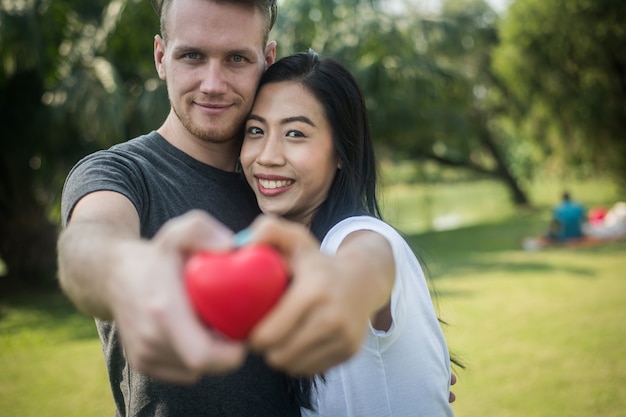 Foto romántico joven pareja mano dolding un corazón