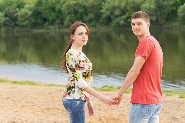 Romántico, pareja joven, posición, tomados de la mano