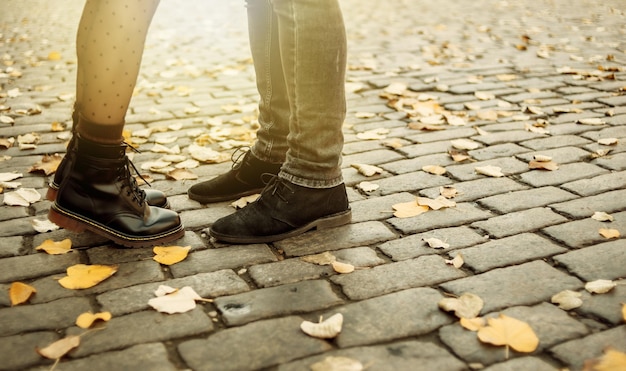 Romantisch, Liebeskonzept. Füße eines jungen verliebten Paares in der Herbststadt. sanfter Kuss des jungen Paares. Liebhaber bei einem romantischen Date, Mädchen stellen sich auf die Zehenspitzen, um ihren Mann zu küssen