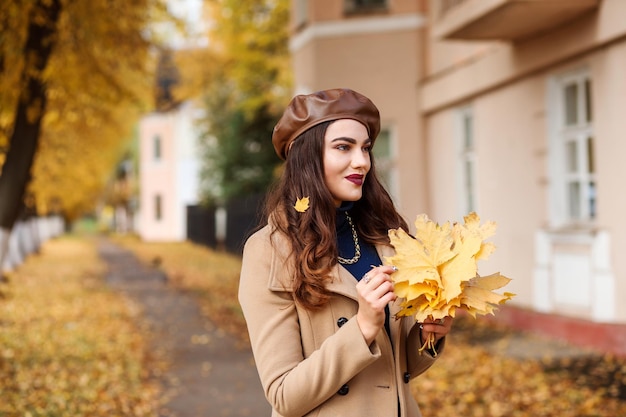 Romantische Frau mit herbstlichem Blumenstrauß, die in der Herbstsaison Zeit im Freien in der Stadtstraße verbringt