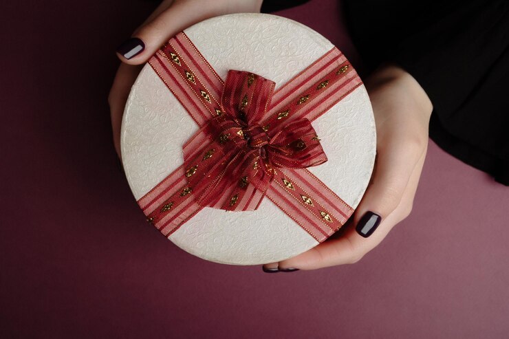 Romantische Geschenkbox Frauenhände halten und geben eine Geschenkbox zum Geburtstag Muttertag