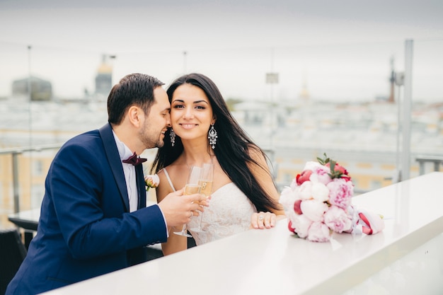 Romantische Jungvermählten trinken Champagner, stossen an und freuen sich sehr, ihre Hochzeit zu feiern