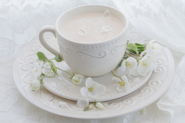 Romantische Komposition mit Teetasse, Zephyr und Apfelblumen