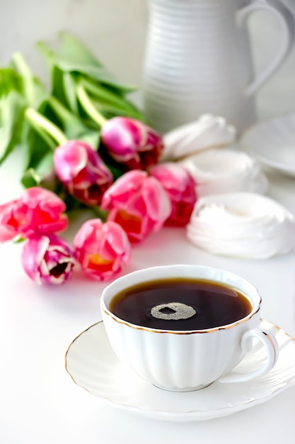 Romantische morgendliche Tasse Tee Blumenstrauß rosa Tulpe Selektiver Fokus