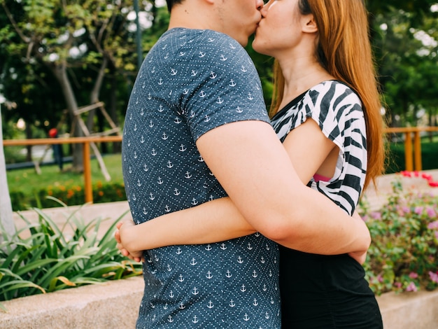 Romantische Paare, die allgemeinen Park im Freien mit Liebe küssen