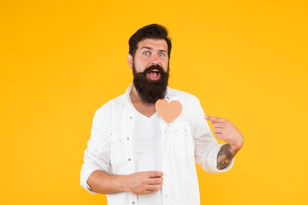 Romantische Stimmung Verlieben Sie sich Happy Valentines Day Bärtiger Mann mit Herz Hipster mit kleinem Herz Valentine Mann mit herzförmiger Karte Ausdruck seiner Liebe Gesundheitskonzept Positive Vibes