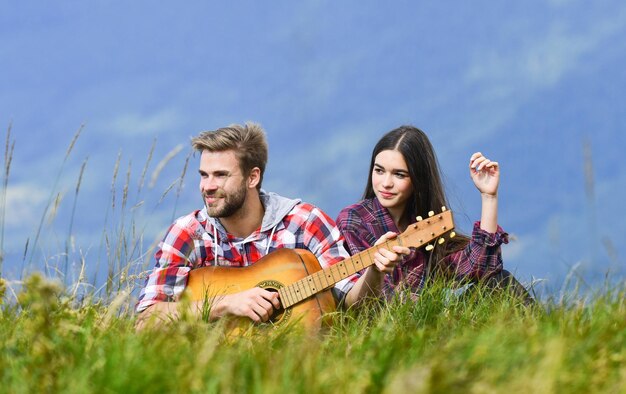 Romantische Stimmung Verliebtes Paar genießt Blick vom Gipfel des Berges Freund spielt Gitarre Singen für sie Romantische Wanderung Romantisches Paar im Sommerurlaub Idyllischer Ort für ein romantisches Date