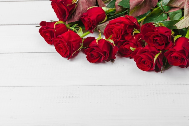 Romantischer Hintergrund mit Rotrose auf hölzerner Tabelle
