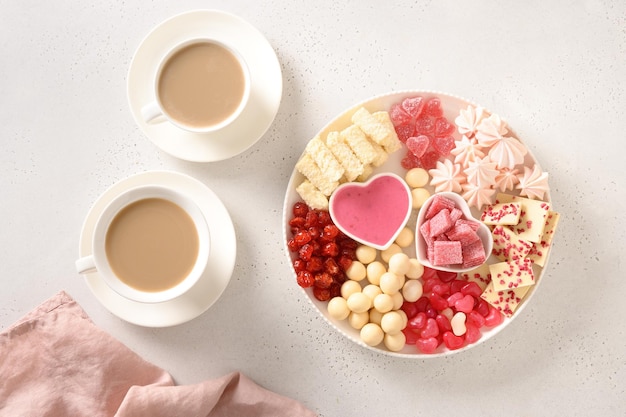 Romantischer Kaffee für zwei und ein Wurstbrett zum Valentinstag mit Schokoladenbonbons und Erdbeeren