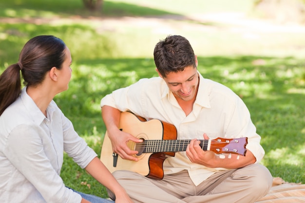 Romantischer Mann, der Gitarre für seine Frau spielt