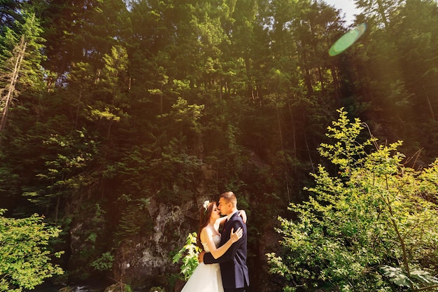 Romantischer Moment der Hochzeit Paar Jungvermählten küssen sich Porträt und schauen sich in der Natur im Park an Hochzeitszeremonie