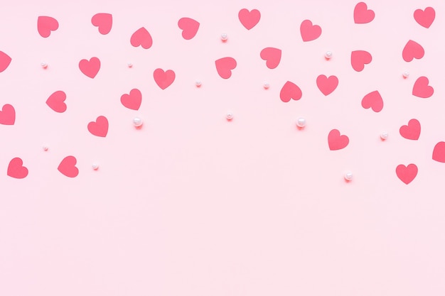 Romantischer rosa Hintergrund mit roten Papierherzen