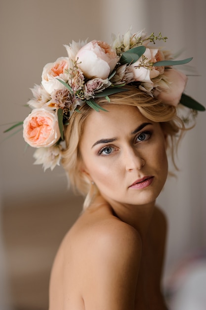 Romantischer schulterfreier Blick von attraktiven Blondinen in einem Blumenkranz