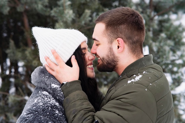 Romantisches glückliches Paar geht im Winter im Park spazieren Mann und Frau umarmen und küssen sich am Valentinstag