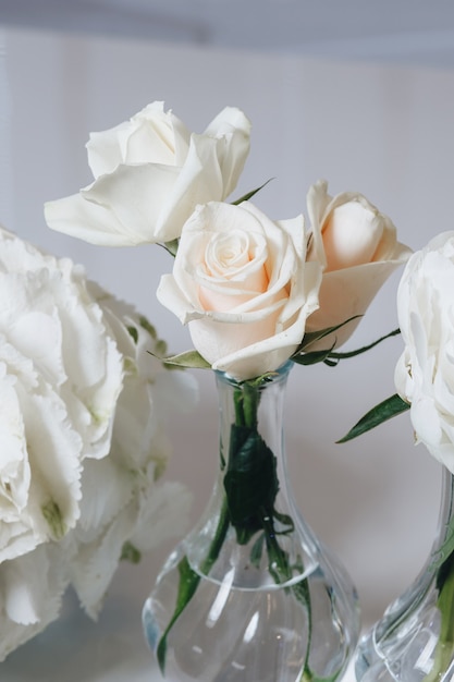 Romantisches Hochzeitstischdekorationsdekor mit großen üppigen Blumensträußen einschließlich weißer Rosen ranunc ...