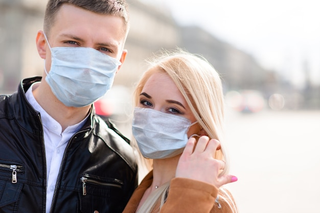 Romantisches junges schönes Paar, das Zeit zusammen genießt, das Schutzmasken trägt