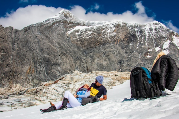 Romantisches Paar, das auf dem Schnee eines schneebedeckten in Peru liegt