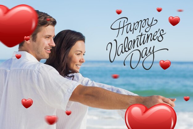 Romantisches Paar, das sich am Strand gegen einen glücklichen Valentinstag entspannt