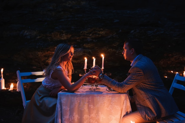 Romantisches Paarhändchenhalten zusammen über Kerzenlicht