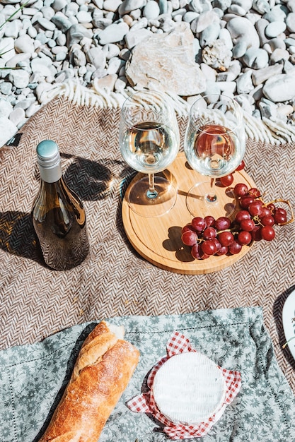 romantisches Picknick an der Küste zwei Weißweingläser Flasche Baguette Käsetraube