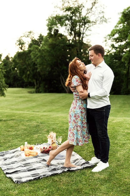 Romantisches Picknick bei Sonnenuntergang. verliebtes Paar beim Mittagessen im Park. Sommerferienzeit. junge Leute bei einem romantischen Date.